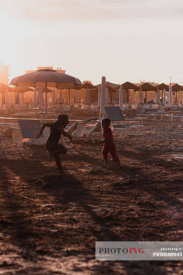 Two children playing on the beach at sunset, Rimini, Emilia Romagna, Italy, Europe