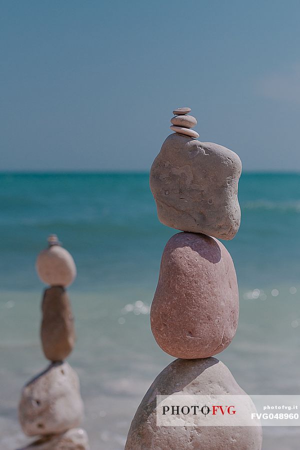 Balanced rock zen stack with the Adriatic sea in the background, Portonovo bay, Conero natural Park, Ancona, Marches, Italy, Europe