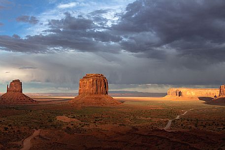 A storm leaving the scenic view of The Mittens and Merrick Butte  from John Wayne's Point during the golden hour at sunset in the Oljato Navajo Monument Valley, Arizona USA 