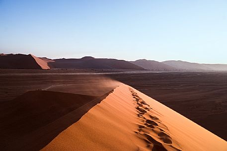 Walking path recovering by the sand on the top of Dune 45 with scenic view of the desert valley in the backgroun,  Namib Naukluft National Park, Namibia, Africa