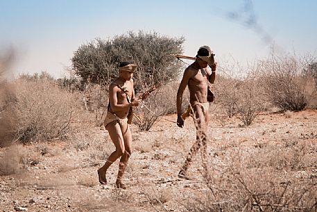 Two San men during a hunting walk in the bush savanna of the Kalahari Desert, Namibia. Africa