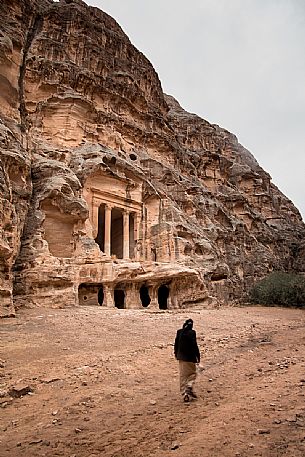 A bedouin walks towards a cave temple of  Duthu Ashara o Dushara in the Little Petra, located 10 miles from the ancient city of Petra, Jordan