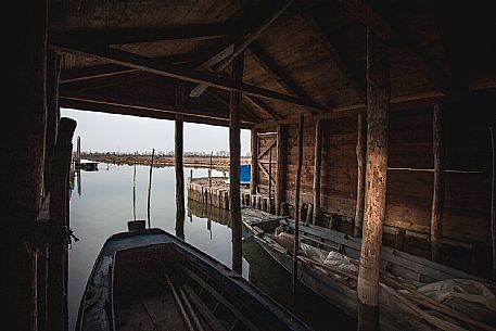 Boats inside a fisherman's pier in the venetian lagoon in Lio Piccolo village, Veneto, Italy, Europe