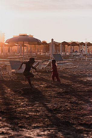 Two children playing on the beach at sunset, Rimini, Emilia Romagna, Italy, Europe