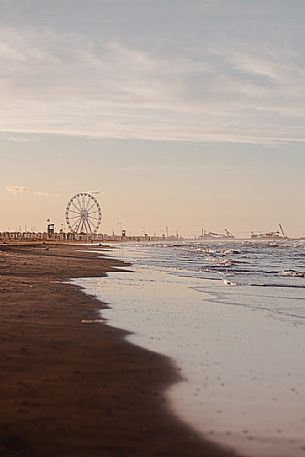 Rimini beach at sunset, ferris wheel and luna park in the background, Rimini, Emilia Romagna, Italy, Europe