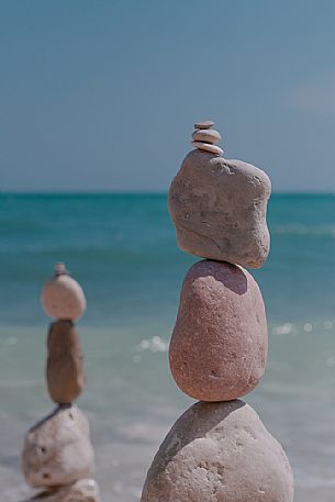 Balanced rock zen stack with the Adriatic sea in the background, Portonovo bay, Conero natural Park, Ancona, Marches, Italy, Europe