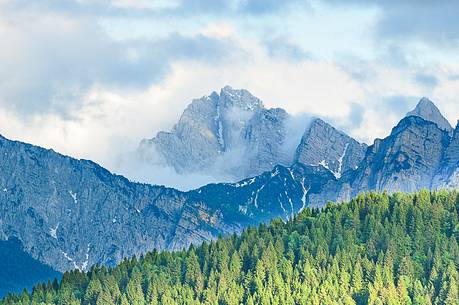 The mount Sernio emerges from the clouds and stands with majesty abiove the green woods The mount Sernio emerges from the clouds and stands with majesty abiove the green woods