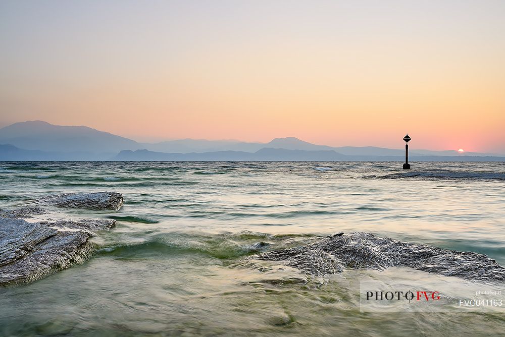 Garda lake form Sirmione village, in the background the silhouettes of Mount Baldo and Mount Pastello, Brescia, Lombardy, Italy, Europe