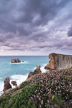 A cloudy view of the magical cliffs on the Atlantic Ocean in Cantabria, Bajos de Arnia, Costa Quebrada, the Broken Coast, group of small islets called Urros de Liencres, Spain