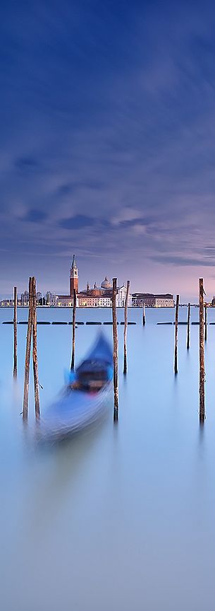 A colorful sunset in the magic mood of Venice with the traditional gondolas in the flow of time, San Giorgio Maggiore church in the background, Venice, Italy