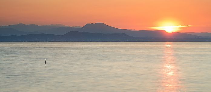 Sunrise on Garda lake from Sirmione, on the right of the Mount Pastello and on the left the Carega mountain group, Brescia, Lombardy, Italy, Europe
