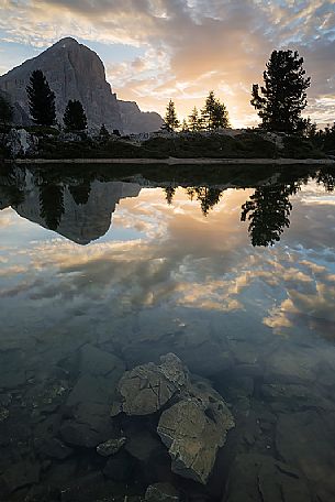 The light of dawn and a perfect reflection of the Tofana on the surface of the Limides lake, Falzarego pass, dolomites, Cortina d'Ampezzo, Veneto, Italy, Europe