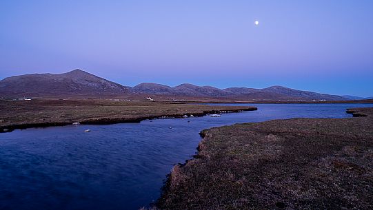 Moonliight between the grass fields washed by the waters of Loch nam Faoileag near Islibhing in the Outer Hebrides on the Isle of Harris, Scotland, 