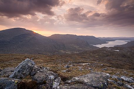 Sunset over a small peak near Aird a 'Mhulaidh watching Loch Langabhat in the Outer Hebrides on the Isle of Harris, Scotland.