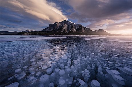 Sunset at Abraham lake with icy bubbles, Canadian Rockies landscape, Banff national park, Alberta, Canada
