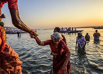 Pilgrims taking ritual bath in the river Ganges in early morning, Varanasi, Uttar Pradesh, India