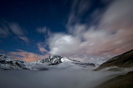 In the night scene with fog and clouds, the stars shining up the Mont Cenis