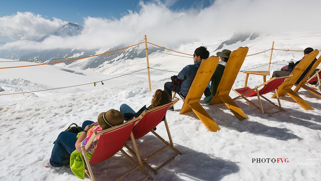 Tourists tanning on top of the Jungfraujoch and admiring the Aletsch glacier, the largest in Europe, Bernese alps, Switzerland, Europe