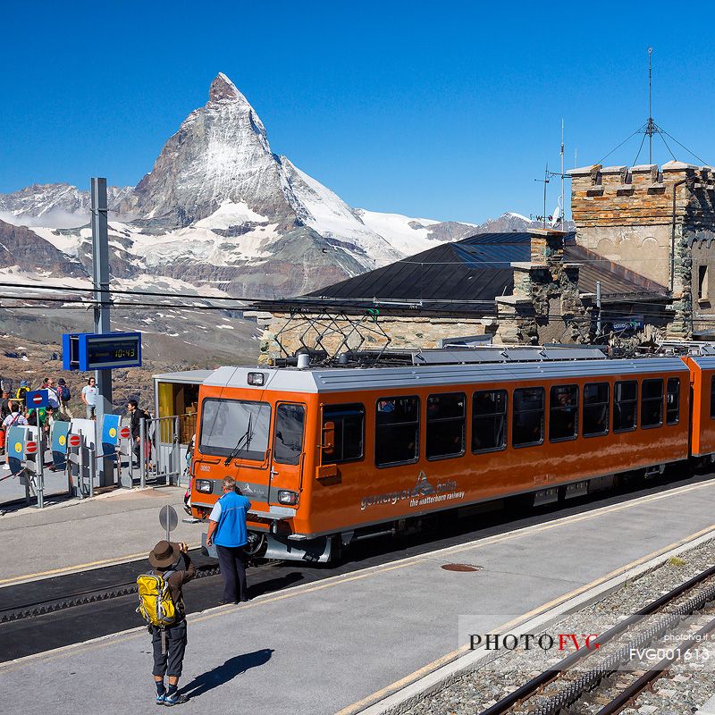 Gornergrat railway station and Swiss train, in the background  the magnificent Cervino or Matterhorn mountain peak, Zermatt, Valais, Switzerland, Europe