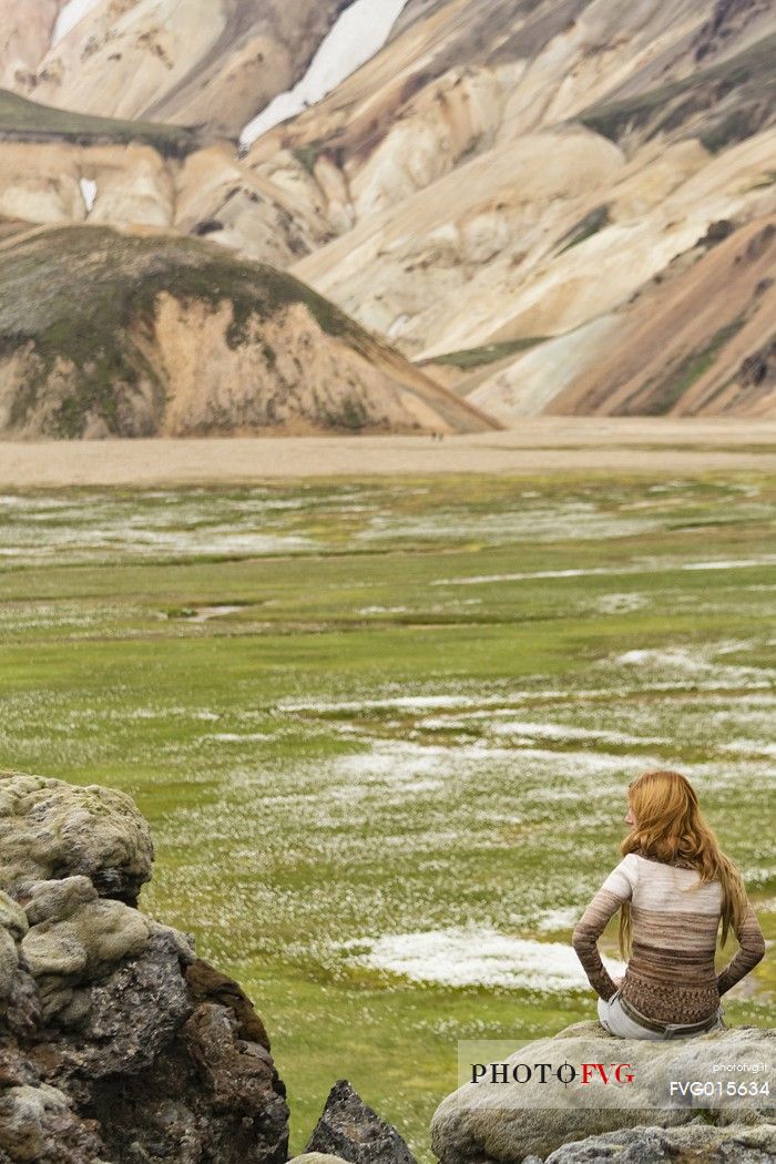 Young girl admires the multicoloured rhyolite mountain area of Landmannalaugar