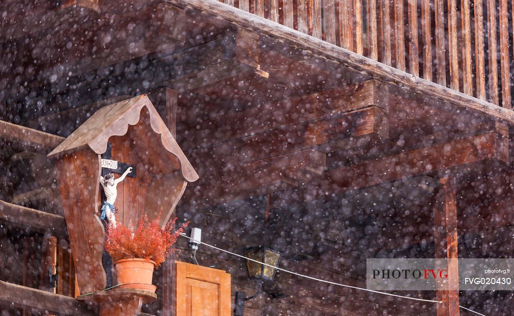 Alpine village of Sauris under a heavy snowfall: wood typical houses. Sauris