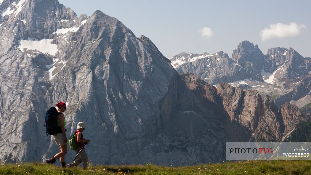 Hikers along the Viel del Pan path, in the background the Marmolada mountain range, dolomites, Italy