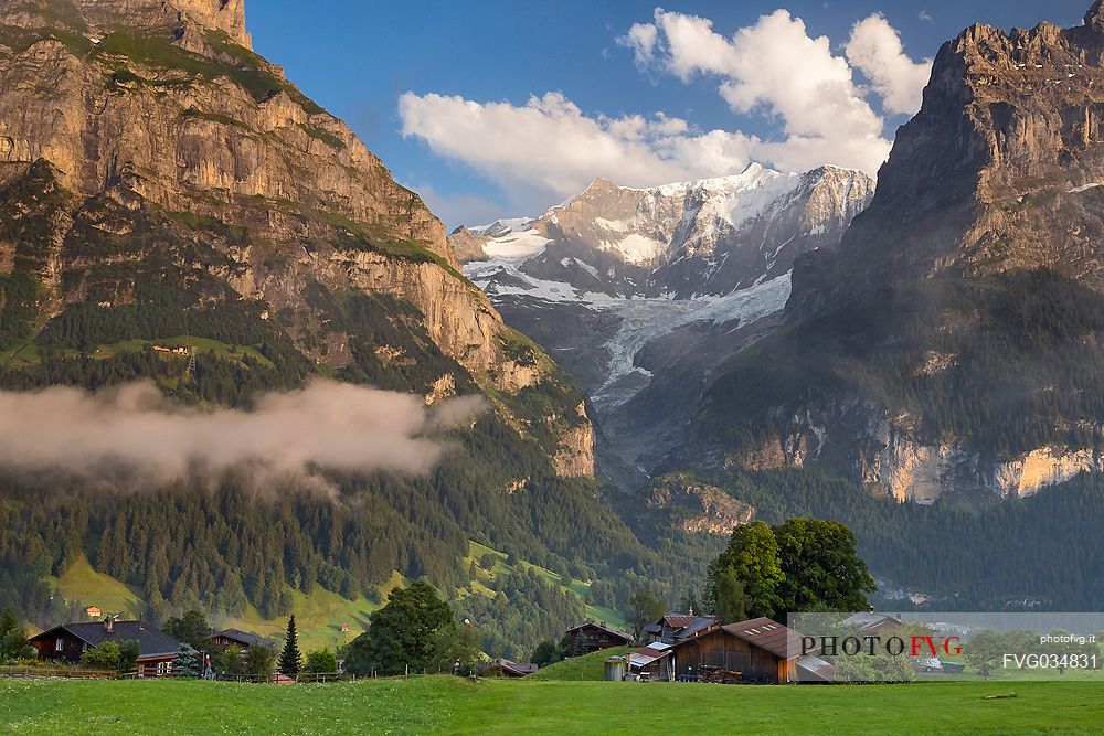 Sunset on Eiger and Fiescherhorn mountain, in foreground typical houses of Grindelwald, Berner Oberland, Switzerland, Europe