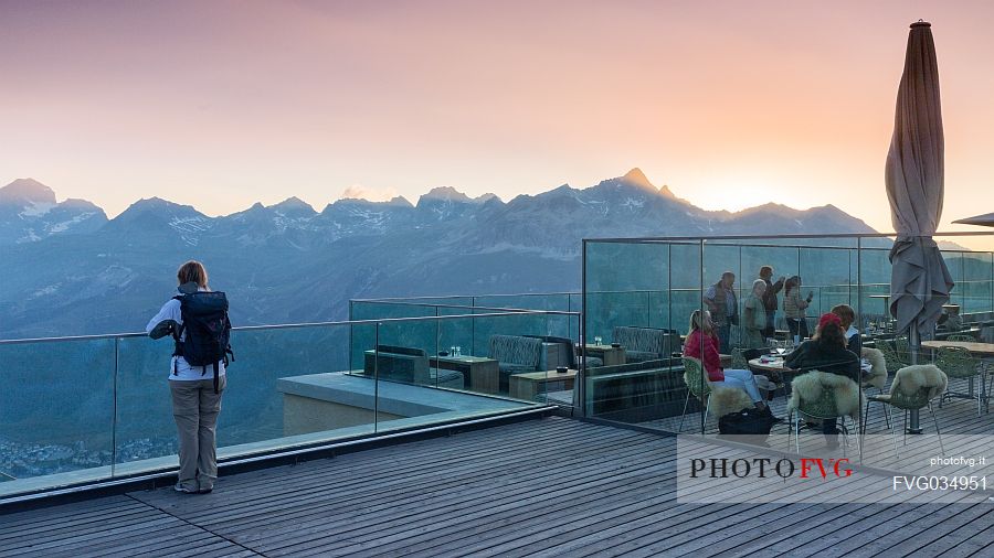 Young woman looking the valley of Saint Moritz at dusk from Romantik Hotel, Muottas Muragl, Samedan, Engadin, Canton of Grisons, Switzerland, Europa