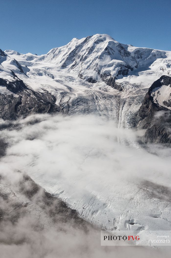 View from Gornergrat mountain towards Monte Rosa or Breithorn mountain range with Liskamm and Gorner Glacier in the clouds, Zermatt, Valais, Switzerland, Europe
 