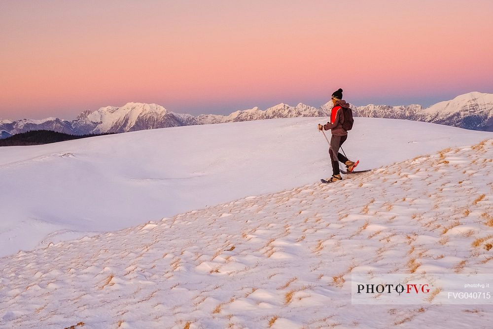 Hiking with snowshoe on the top of Pizzoc mount, in the background the Cavallo mountain range, Cansiglio, Veneto, Italy, Europe