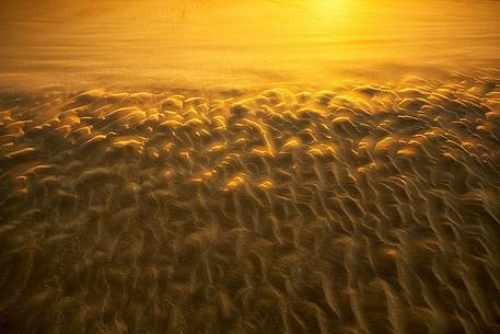 The gold sand of the beach in front of Bamburgh castle