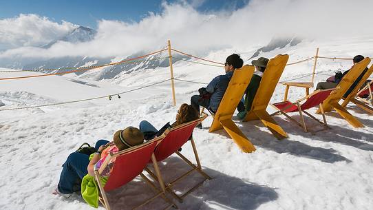 Tourists tanning on top of the Jungfraujoch and admiring the Aletsch glacier, the largest in Europe, Bernese alps, Switzerland, Europe