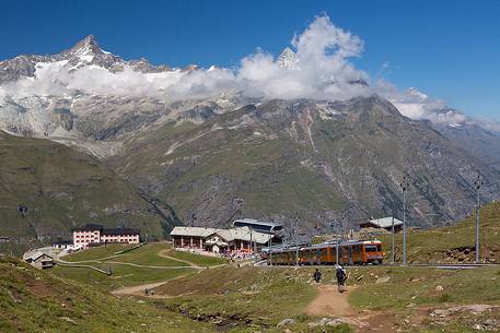 Train of Gornergrat railway at Riffelalp, in the background the mountain range over Zermatt village, Valais, Switzerland, Europe Train of Gornergrat railway at Riffelalp, in the background the mountain range over Zermatt village, Valais, Switzerland, Europe