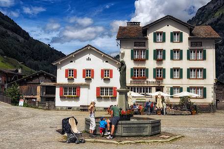 Tourist at the fountain of Vals village, Grisons, Switzerland, Europe