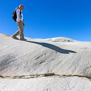 Tourist walks in the rocks of the Rhone glacier, Furka pass, Valais, Switzerland, Europe