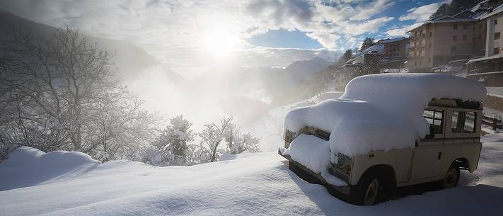 An old Land Rover covered by snow in Casso alpine town after an intense snowfall An old Land Rover covered by snow in Casso alpine town after an intense snowfall