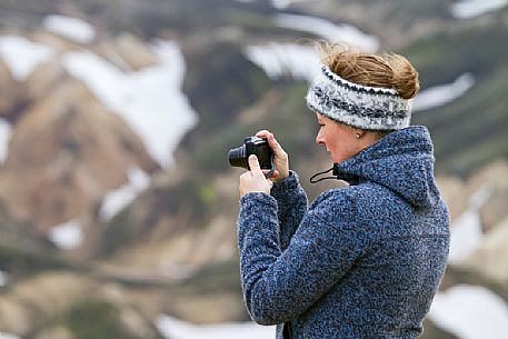 Young girl takes photos in the multicoloured rhyolite mountain area of Landmannalaugar Young girl takes photos in the multicoloured rhyolite mountain area of Landmannalaugar