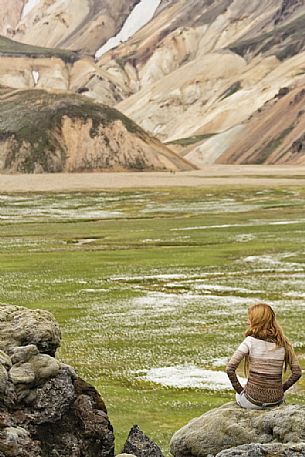 Young girl admires the multicoloured rhyolite mountain area of Landmannalaugar Young girl admires the multicoloured rhyolite mountain area of Landmannalaugar