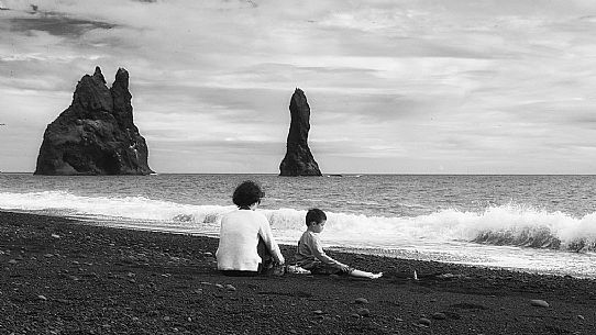 A family, mother and child, relaxing in the Vik beach