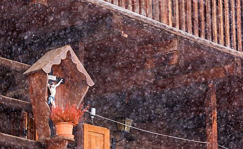 Alpine village of Sauris under a heavy snowfall: wood typical houses. Sauris