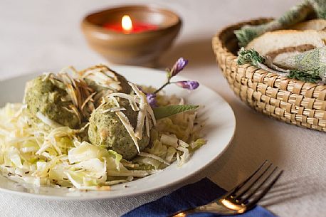 Typical platter of dumplings and sauerkraut with parmesan shavingsin Malga Rinfreddo, Comelico, Dolomites, Italy