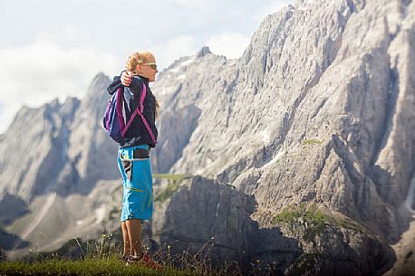 A young hiker looks the Popera group in the Sesto Dolomites from Forcella Pian della Biscia, Comelico, Italy