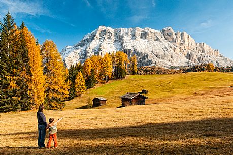 Mother and child admiring the Dolomite's autumn landscape, Prati dell'Armentara, Sasso della Croce mountain group in background, Badia Valley, Italy, Fanes Senes Braies Natural Park 