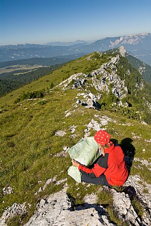 Hiker on the top of mount Manderiolo, Asiago, Italy
