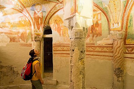 Tourist visiting the crypt and the magnificent frescoes of the Basilica of Aquileia, Italy