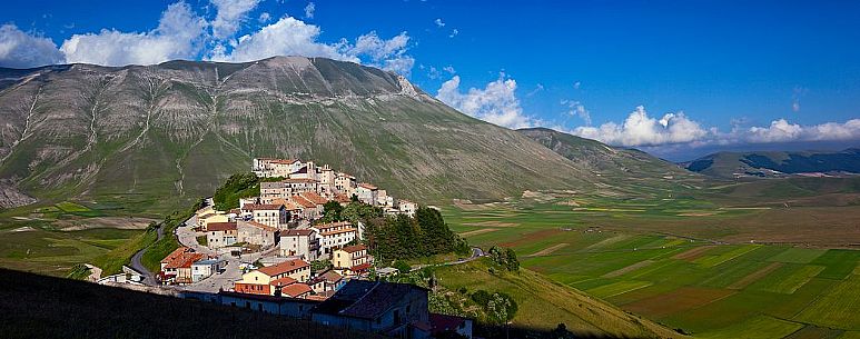 The olf village of Castelluccio before the disastrous earthquake of 2016 in the background the fields planted with lentil, Italy