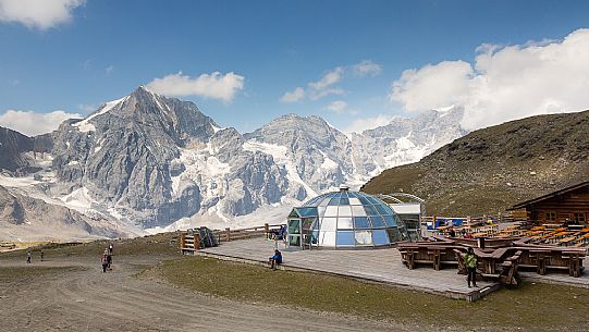 Hikers at Madriccio hut and in the background the Gran Zebr peak or Knig Spitze, Solda valley, Stelvio national park, South Tyrol, Italy