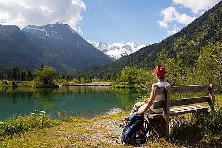Hiker in the Val Morteratsch valley admiring the glacier and the Bernina mountain range, Pontresina, Engadine, Canton of Grisons, Switzerland, Europe