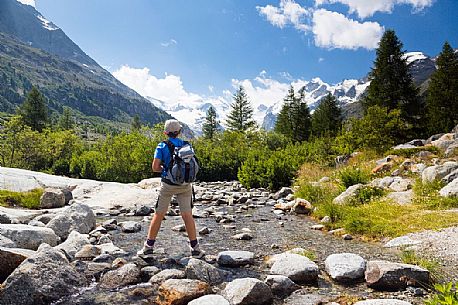 Hiking in Val Morteratsch valley, in the backgrond the glacier and the Bernina mountain range, Pontresina, Engadine, Canton of Grisons, Switzerland, Europe