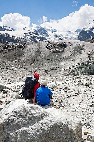 Hikers in Val Morteratsch valley, in the backgrond the glacier and the Bernina mountain range, Pontresina, Engadine, Canton of Grisons, Switzerland, Europe